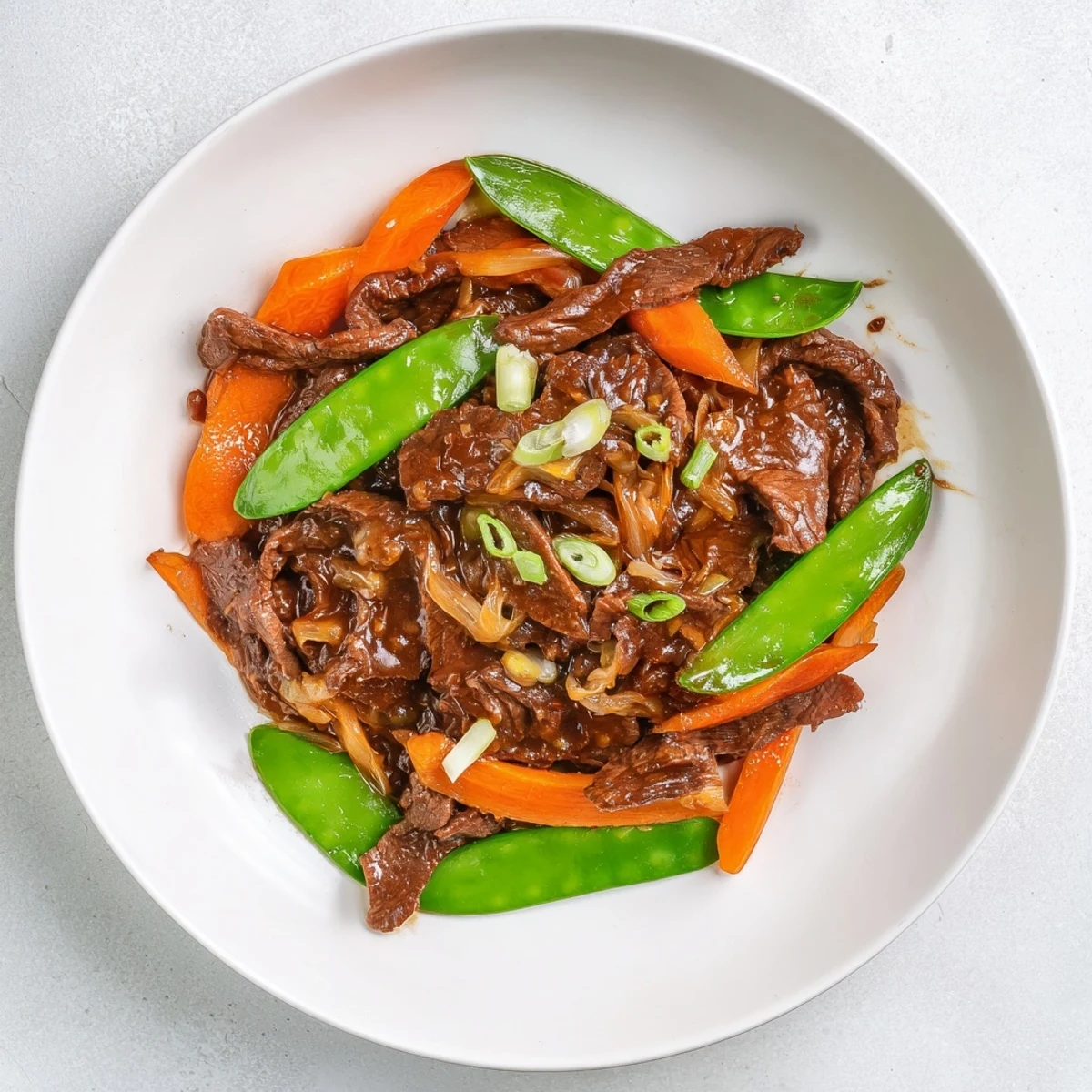 Tender beef, crisp snow peas, and bright carrots shine in this Beef Stir Fry with Snow Peas and Carrots, ready to serve over steamed rice.  