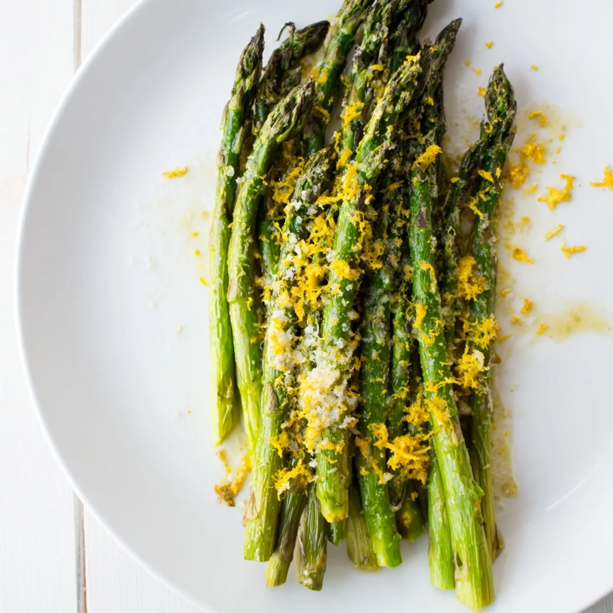 A simple, elegant side of roasted asparagus with melted Parmesan and lemon zest, served warm on a platter.
