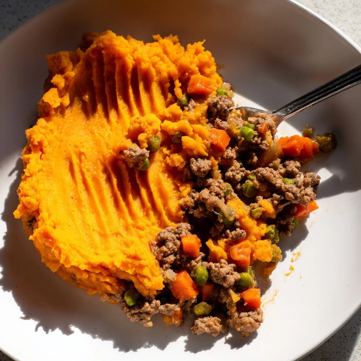 Golden brown Beef Shepherds Pie with Sweet Potato Topping, served bubbling hot in a rustic dish for a cozy family dinner.
