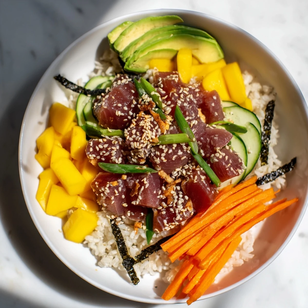 Bright and bold, a Spicy Tuna Poke Bowl with Mango features marinated tuna and mango chunks over warm rice.