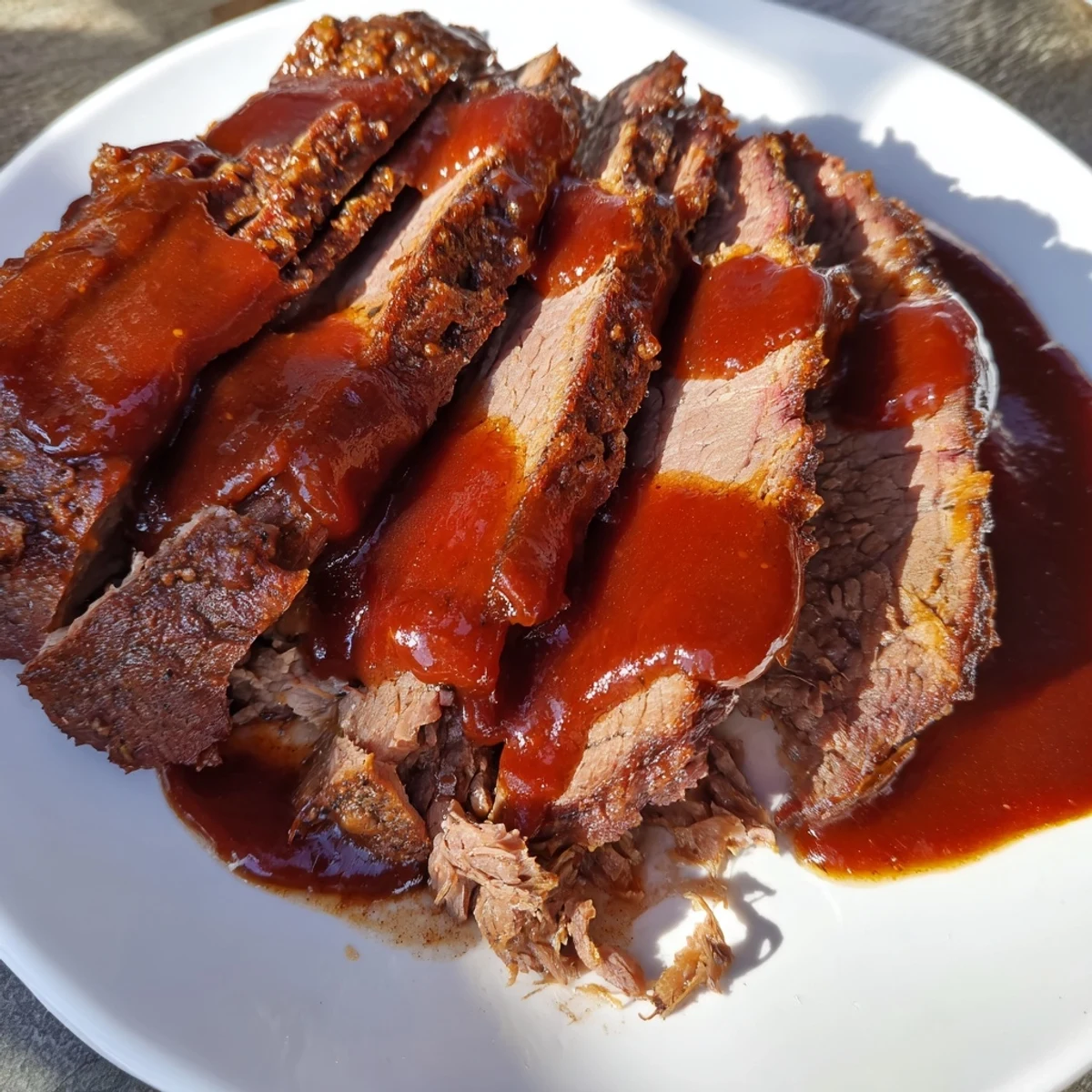Slow Cooked Beef Brisket with BBQ Sauce, glazed in a smoky homemade sauce, sliced against the grain.