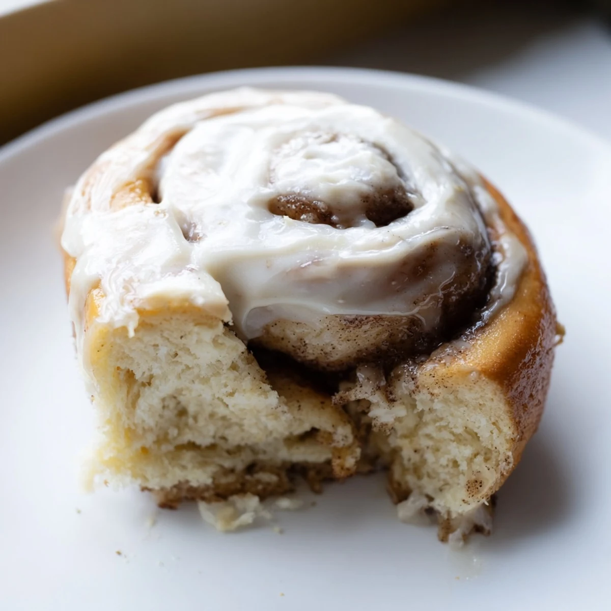 Warm keto cinnamon buns arranged in a round pan, showcasing a soft fluffy texture and golden crust.