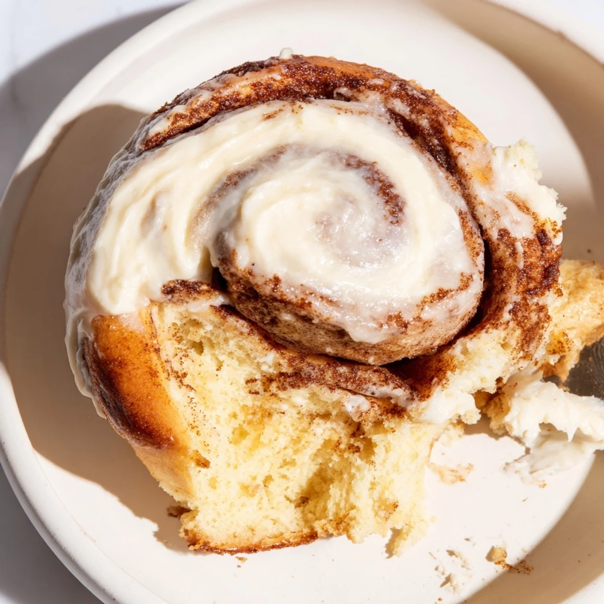 Freshly baked keto cinnamon buns cooling on a wire rack with a drizzle of cream cheese icing.