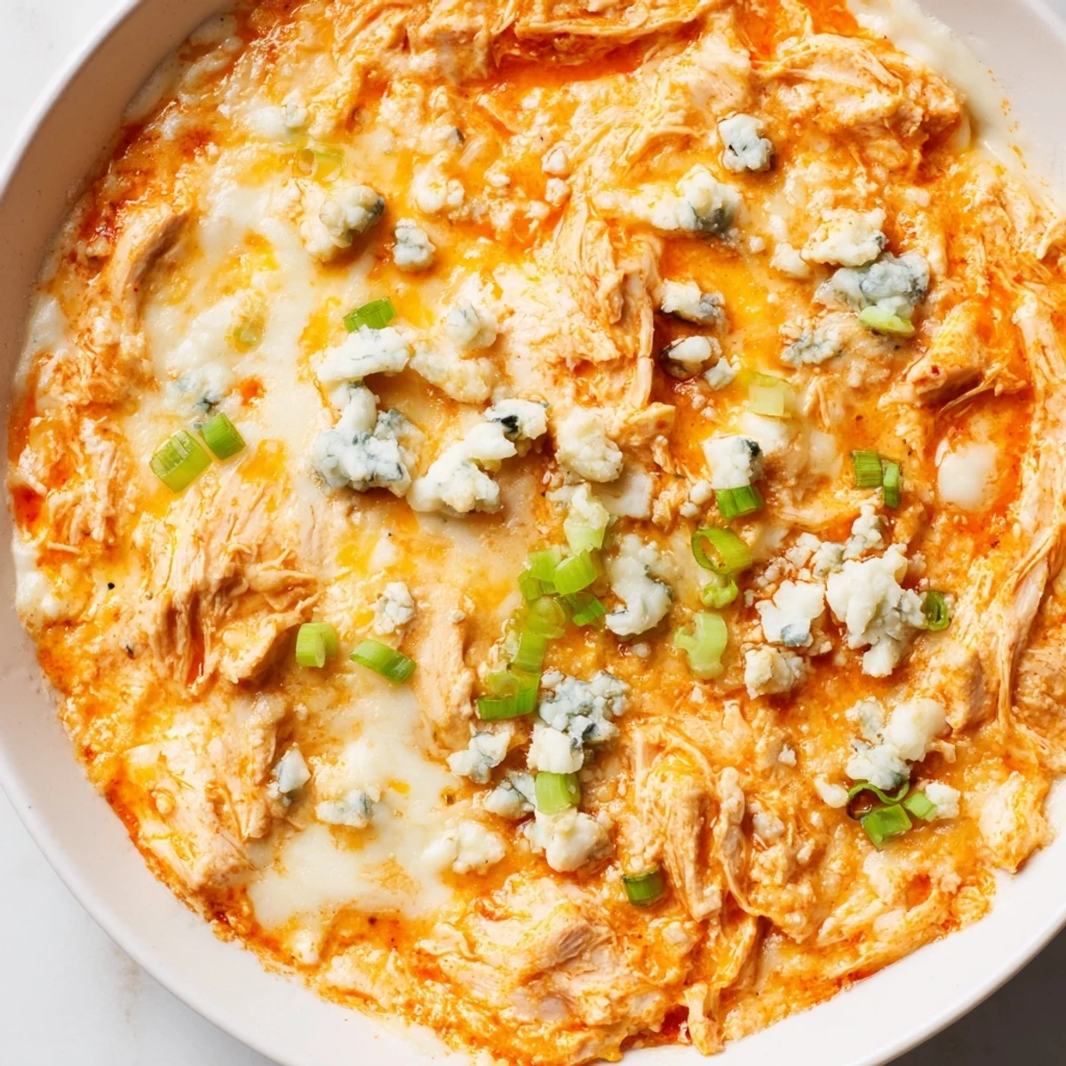 A close-up of creamy Keto Buffalo Chicken Dip with melted cheese and a spicy buffalo sauce aroma, ready for a low-carb party.