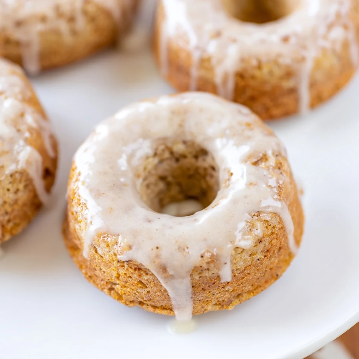 Golden-brown Baked Banana Bread Donuts glazed and resting on a wire rack, with soft crumb and ripe banana aroma.