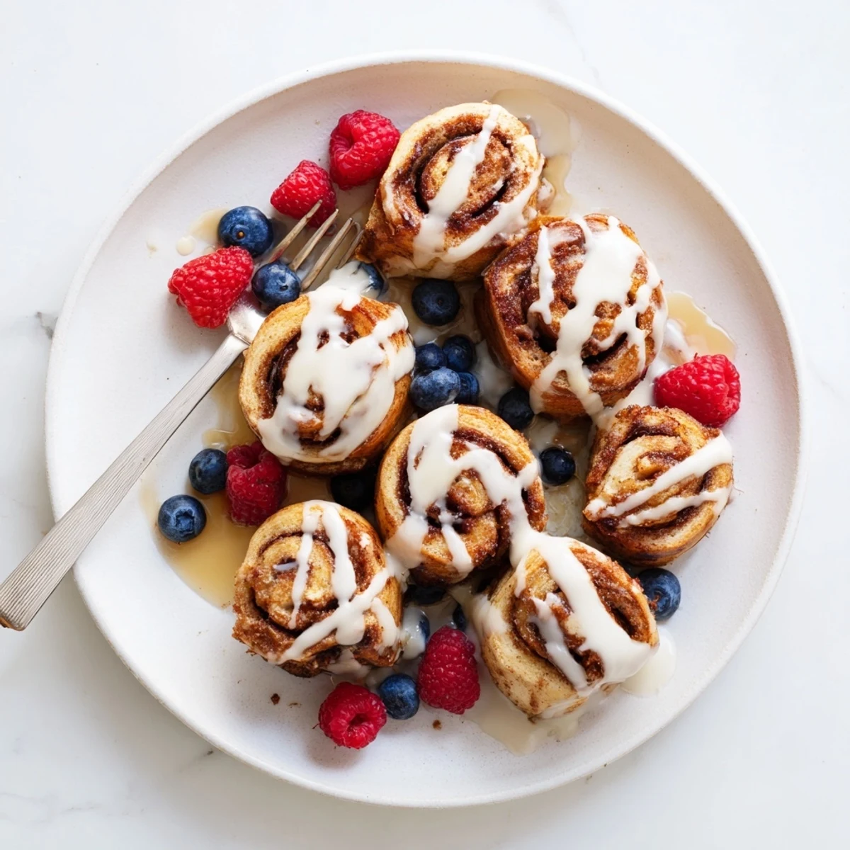 Overhead view of cooked Cinnamon Roll French Toast Bites in a skillet, garnished with cinnamon and ready to serve.