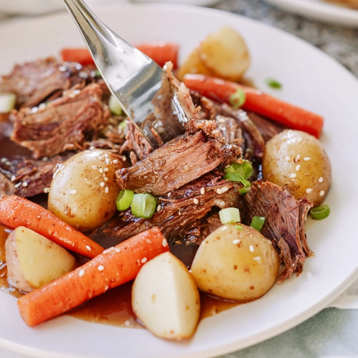 Slow cooker Korean Beef Pot Roast with tender shredded meat and rich soy garlic gravy ladled over rice.