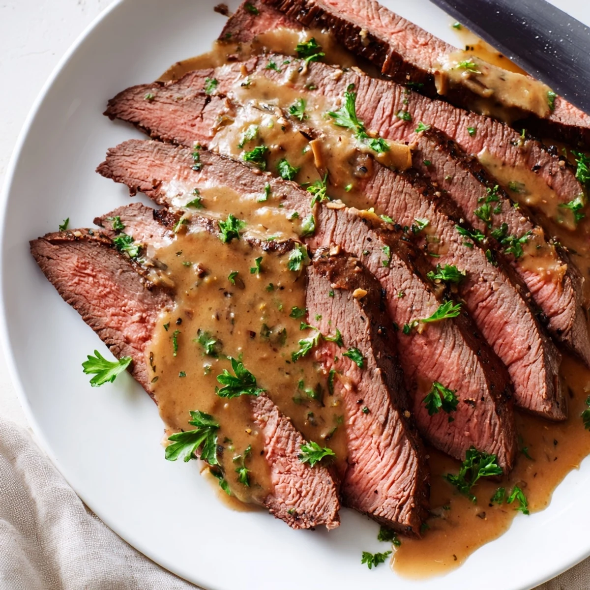 Sizzling flank steak resting before sliced thin, served with a velvety roasted garlic sauce.