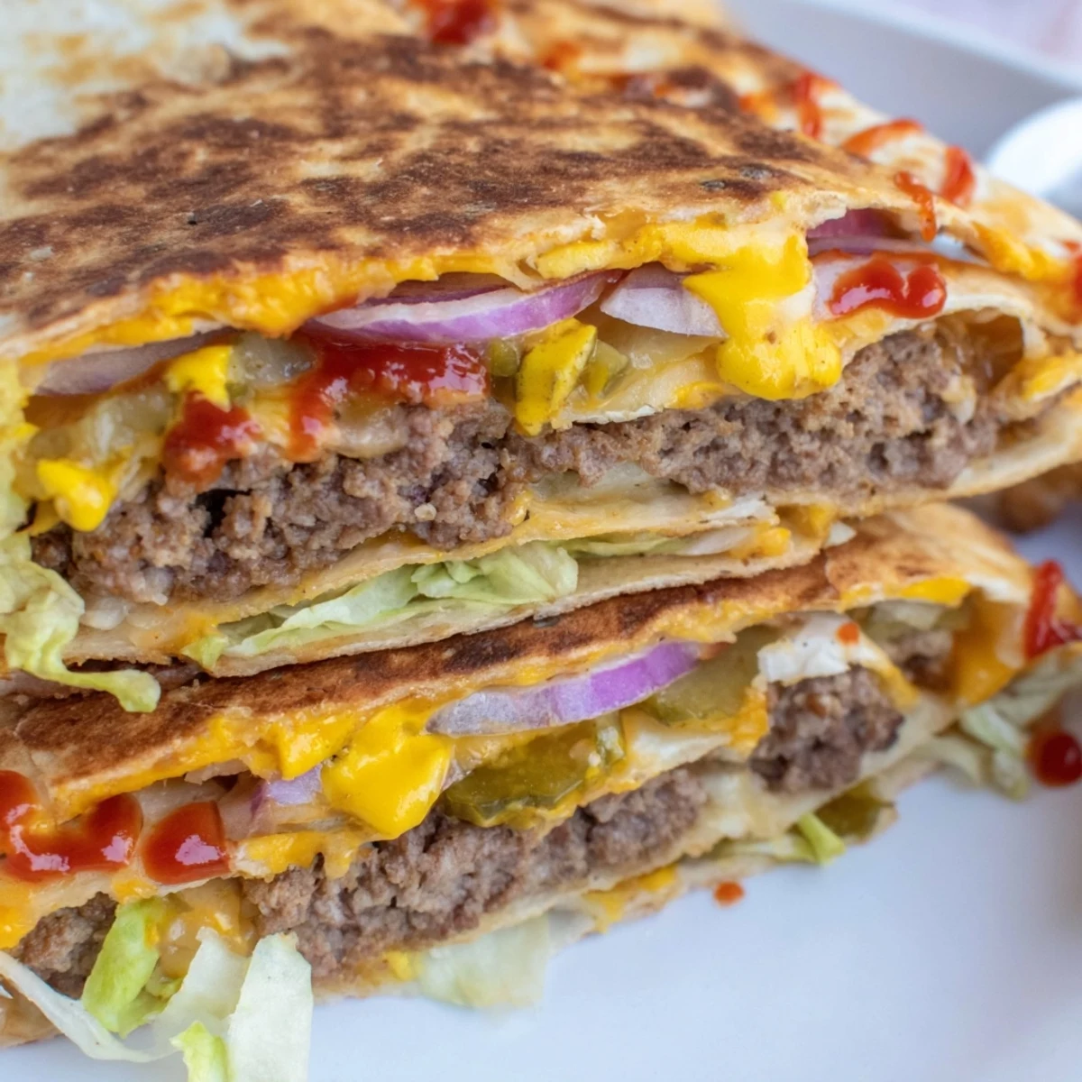 Golden crispy smashburger quesadillas sliced into triangles revealing melted cheese and juicy seasoned beef patties inside