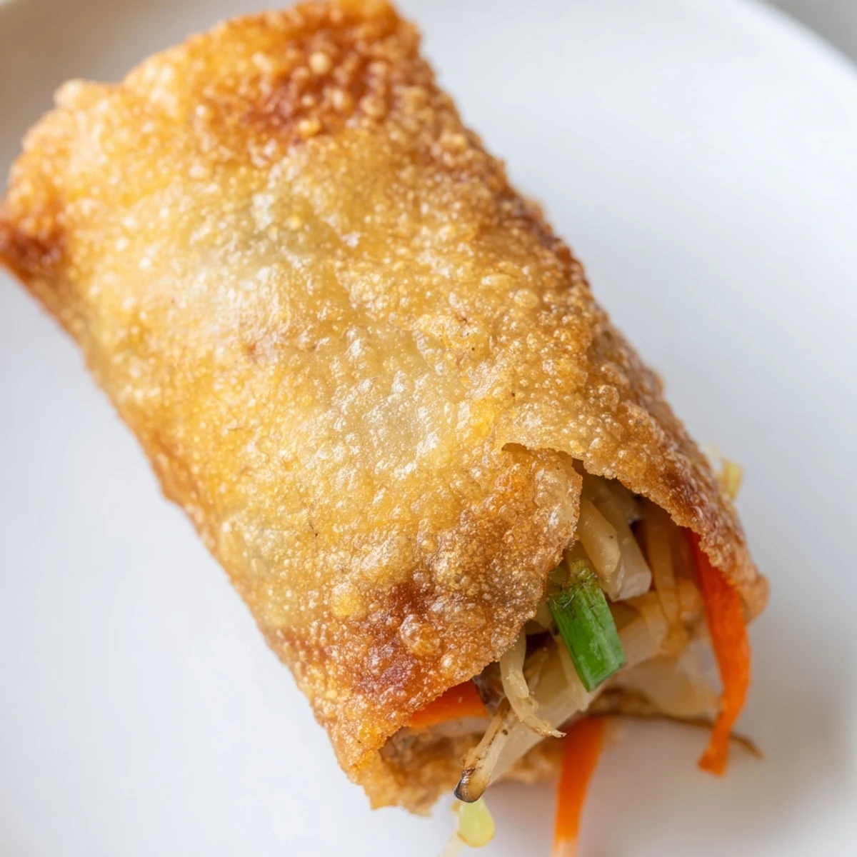Fresh vegetable filled crispy spring rolls frying in bubbling hot oil until golden brown