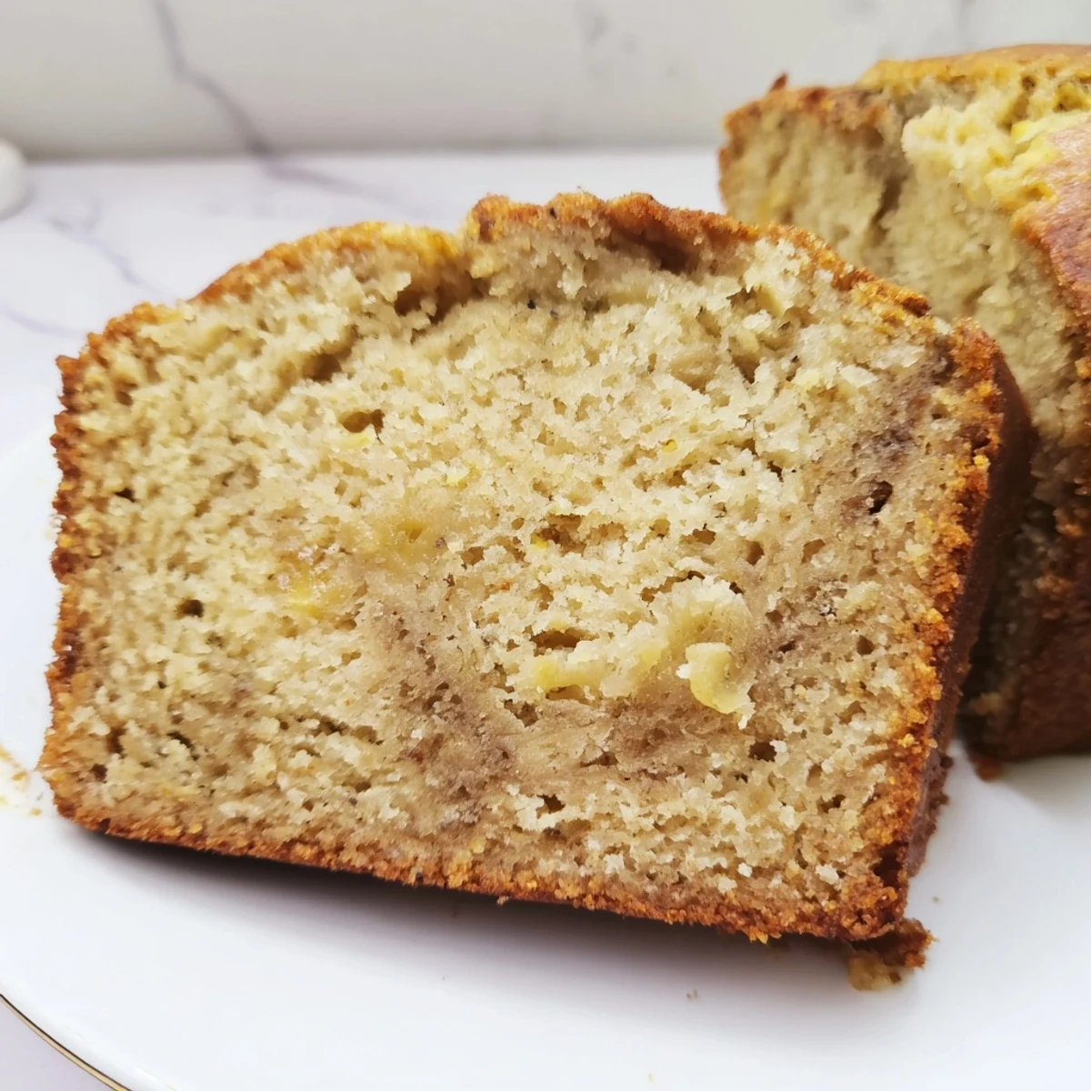 Slices of delicious banana bread arranged on a wooden board, showcasing the soft tender interior and dark golden crust