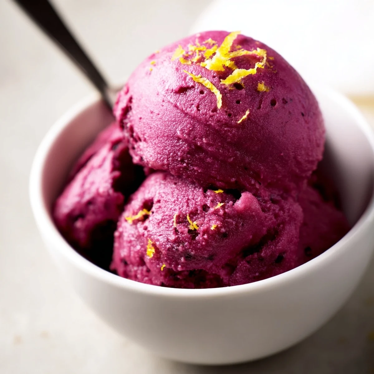 Creamy dairy-free no churn blueberry lemon sorbet topped with lemon zest and fresh mint