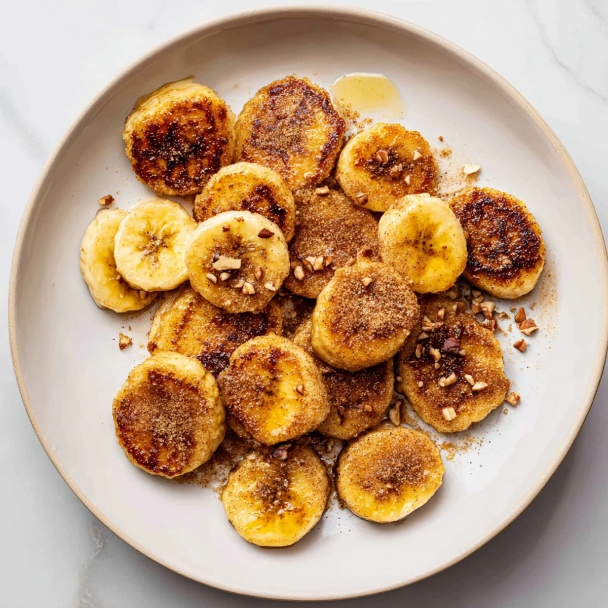 Golden pan fried cinnamon bananas sizzling in butter with caramelized edges and warm brown sugar coating