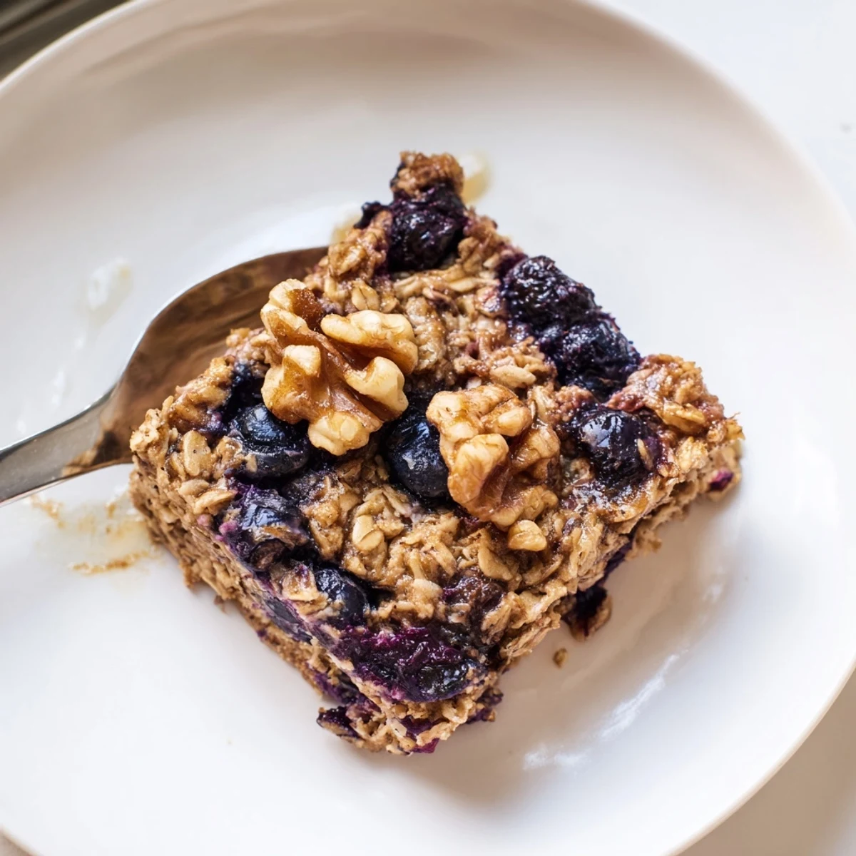 Warm bowl of lemon blueberry baked oatmeal topped with plump juicy berries