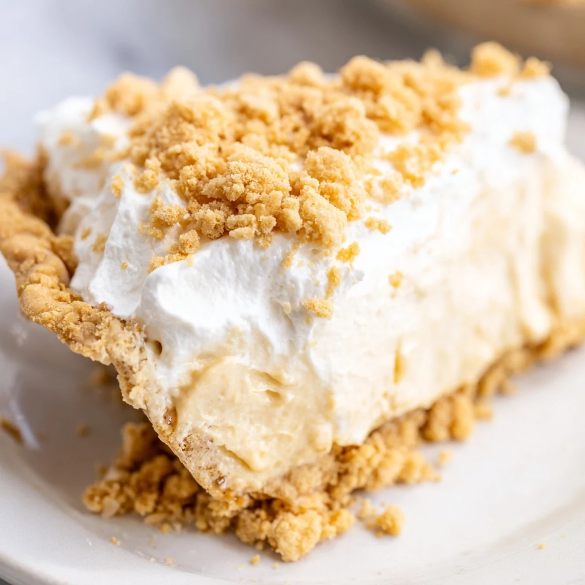 Creamy Amish peanut butter dream pie topped with fluffy whipped cream and golden crumb topping