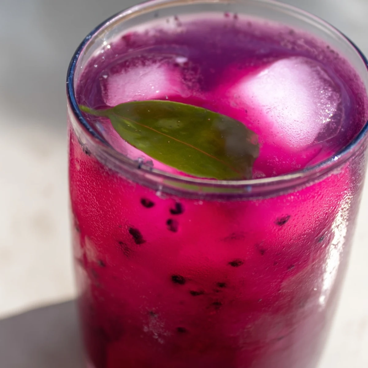 Chilled Grape Agua Fresca served in mason jars with lime wedges on a sunny patio table