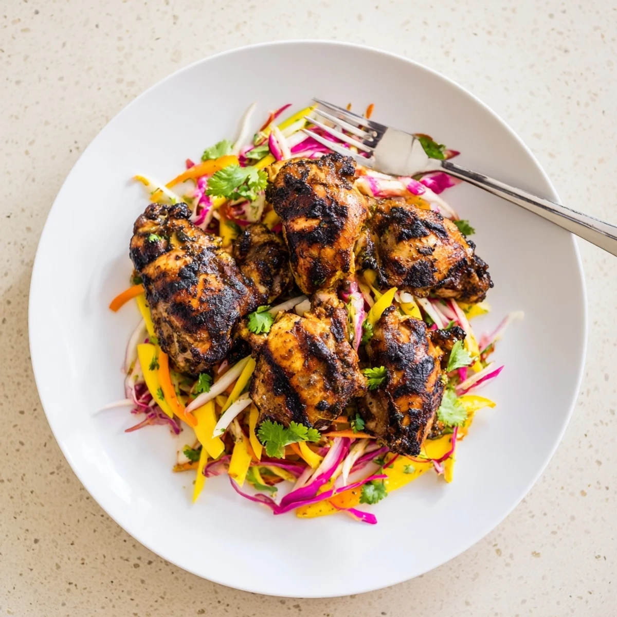 Charred spicy jerk chicken sliced over a bright crunchy mango slaw