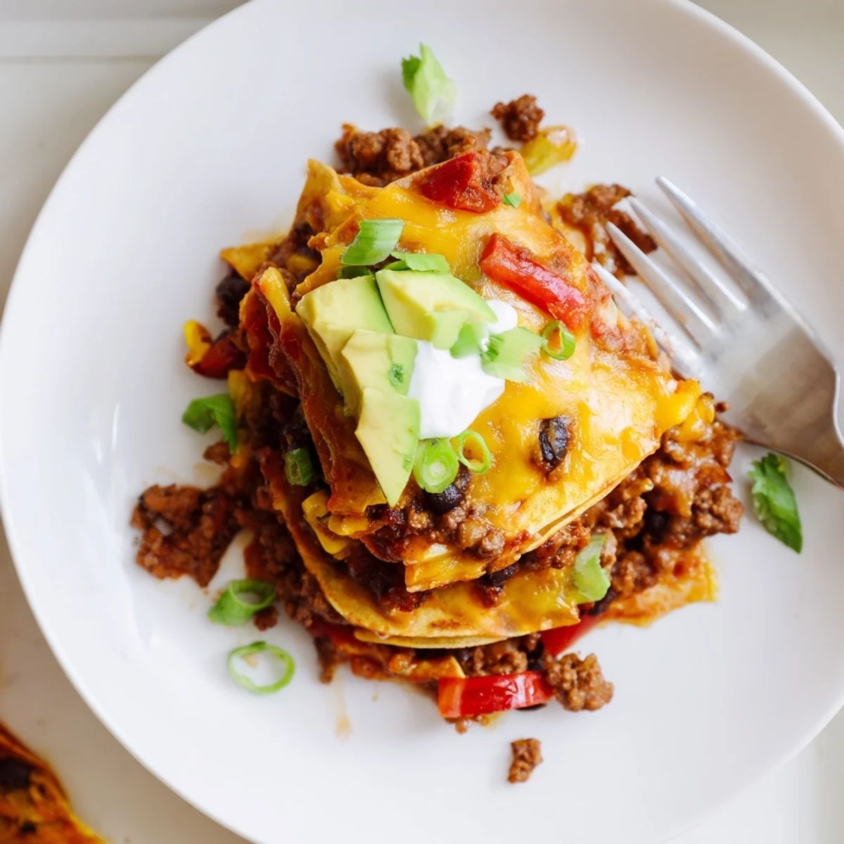 Beef Skillet Enchiladas bubbling with melted cheese, red sauce and cilantro garnish