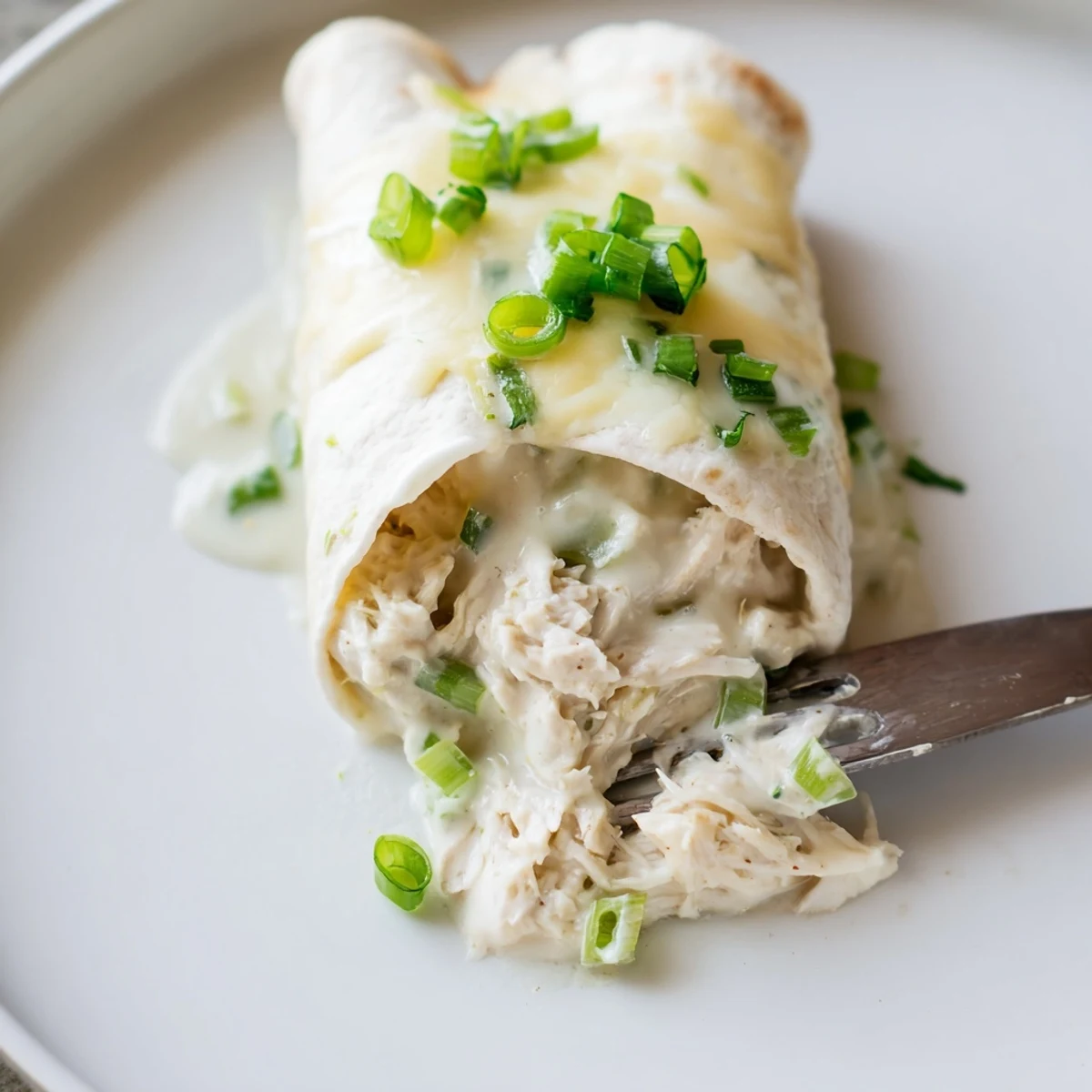 Rolled in soft tortillas, Creamy White Chicken Enchiladas glisten with velvety sauce