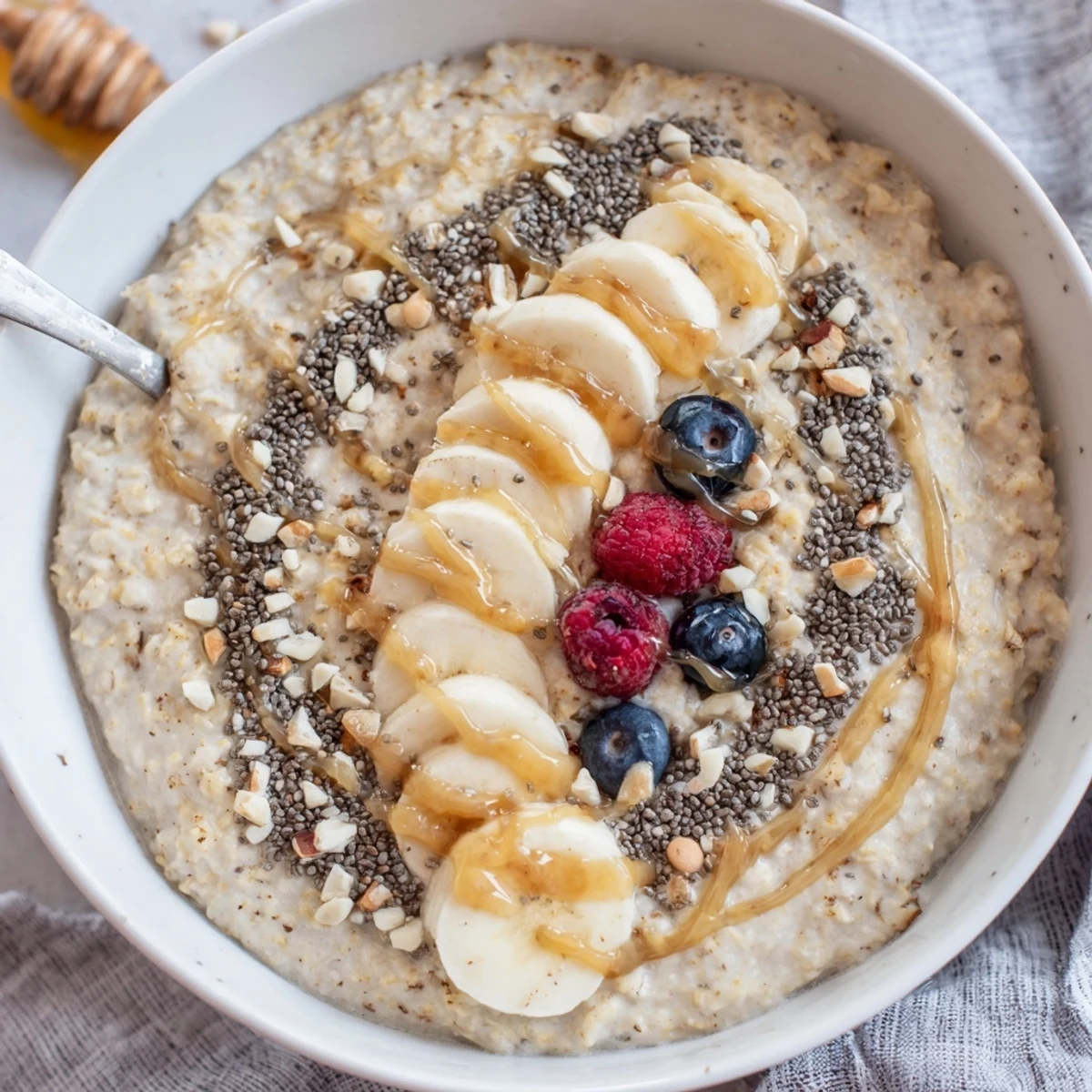 Creamy Protein Oatmeal topped with sliced banana, nuts, and fresh berries