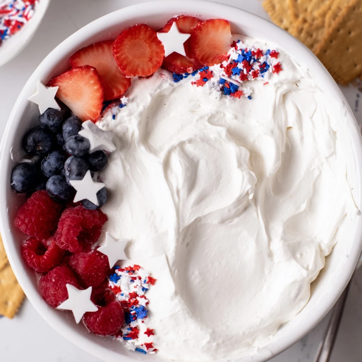 Creamy Star Spangled Cheesecake Dip swirled smooth, served with graham crackers
