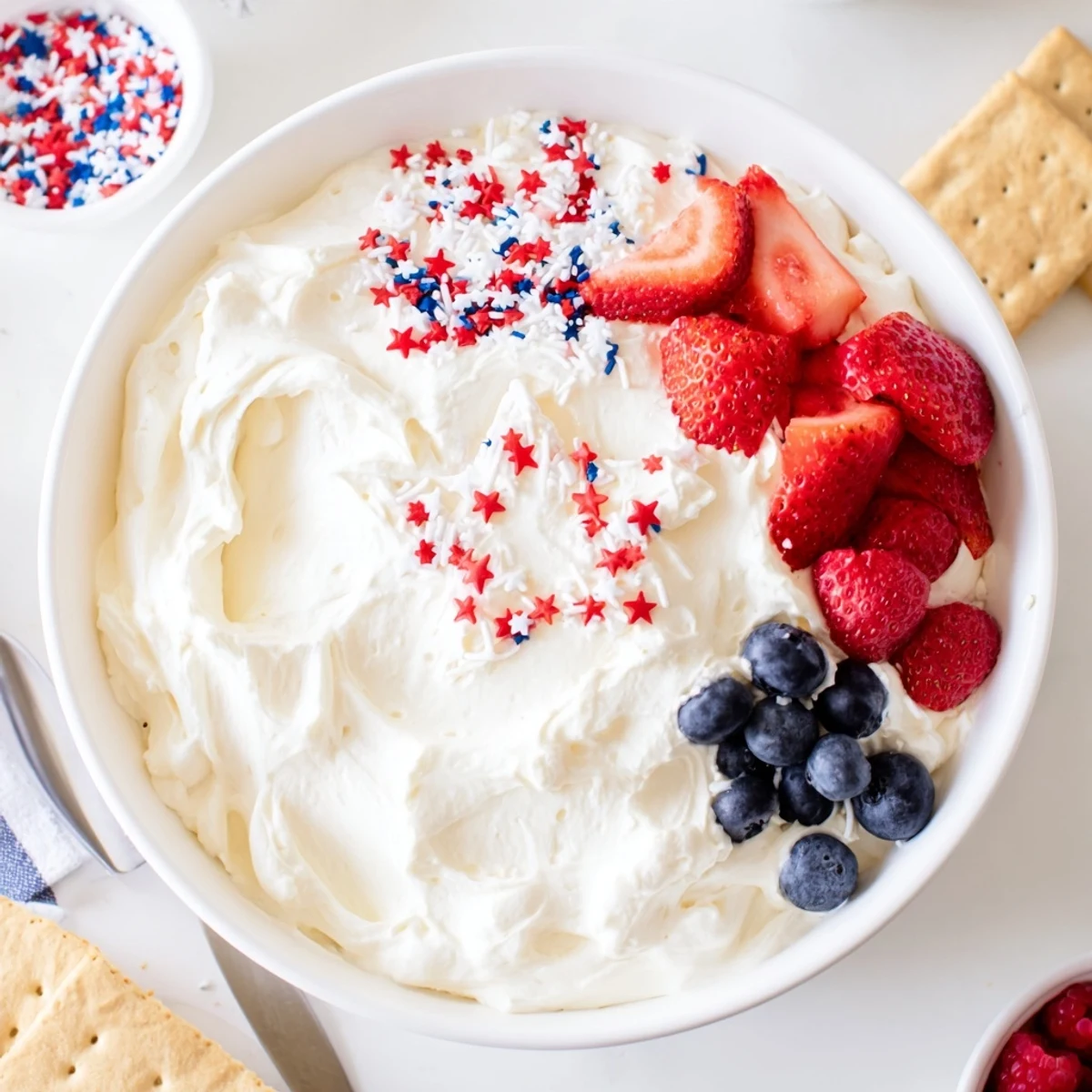 Festive Star Spangled Cheesecake Dip arranged in flag pattern, berries glistening