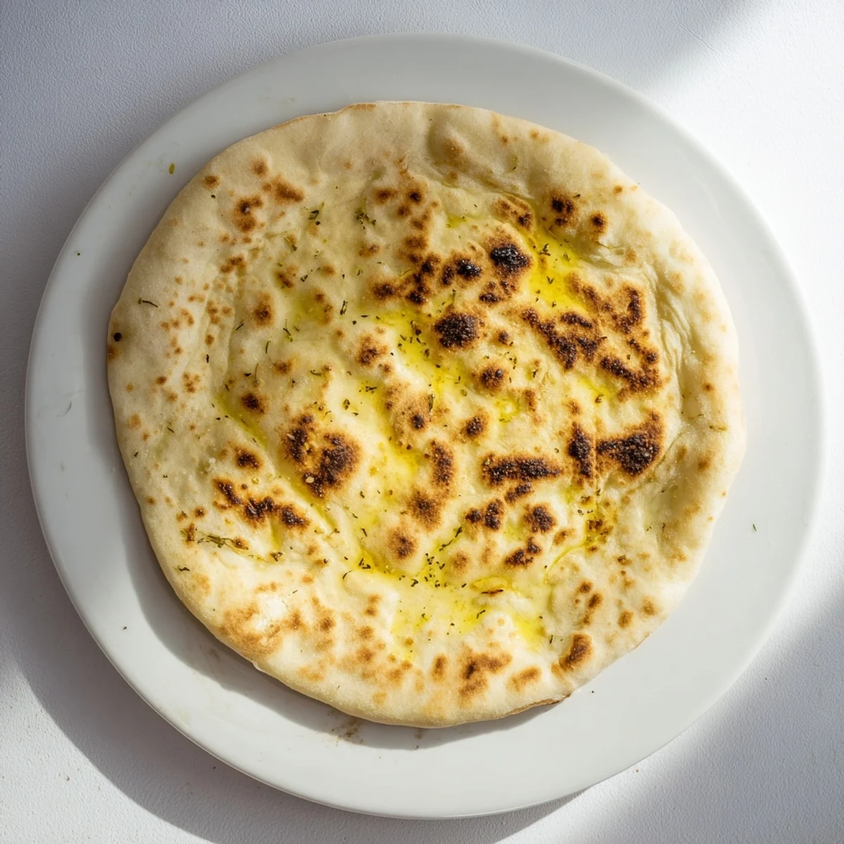 Golden brown Turkish Bazlama flatbread with soft pillowy texture and characteristic air bubbles