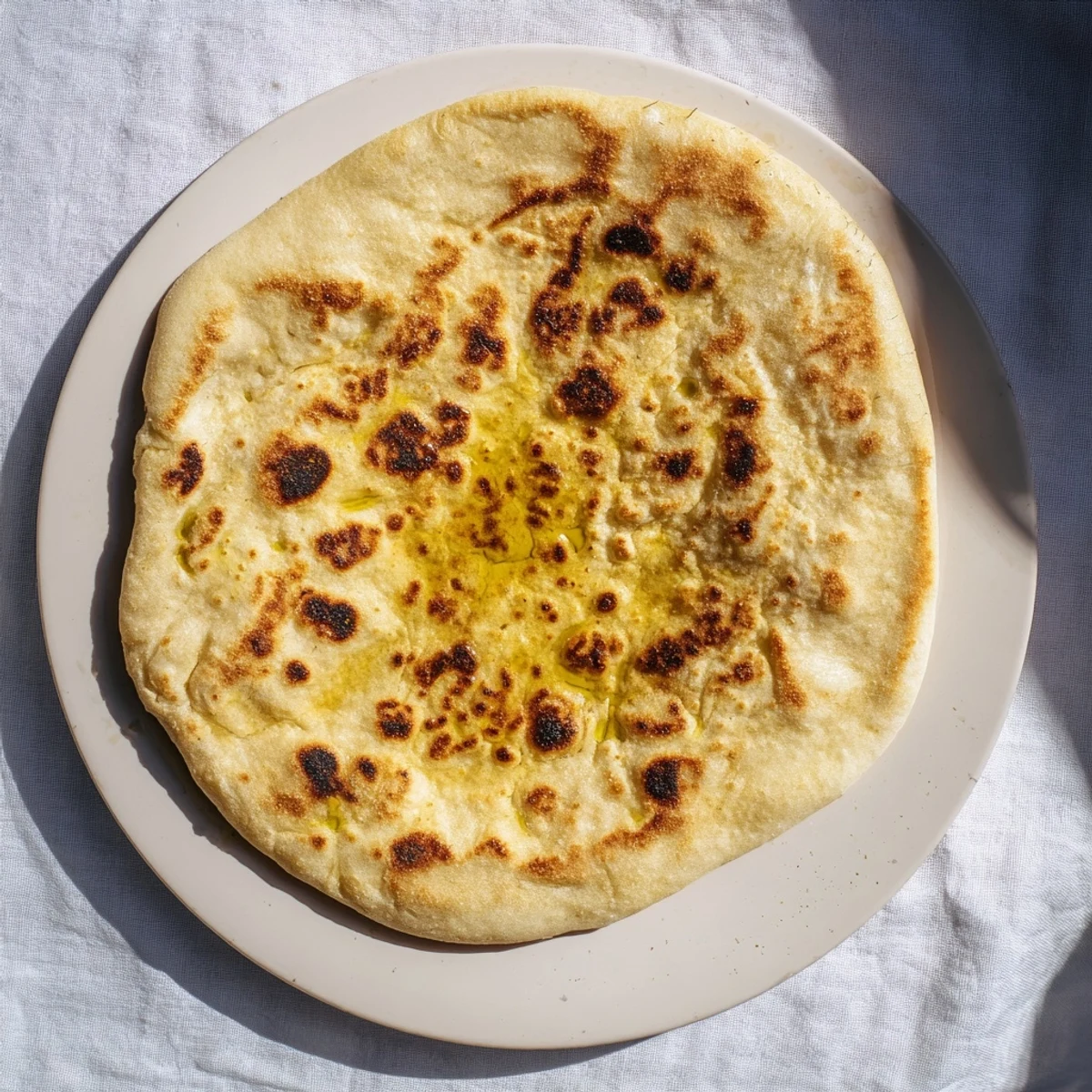 Freshly cooked Turkish Bazlama bread displaying golden spots and thick chewy crust perfect for dipping