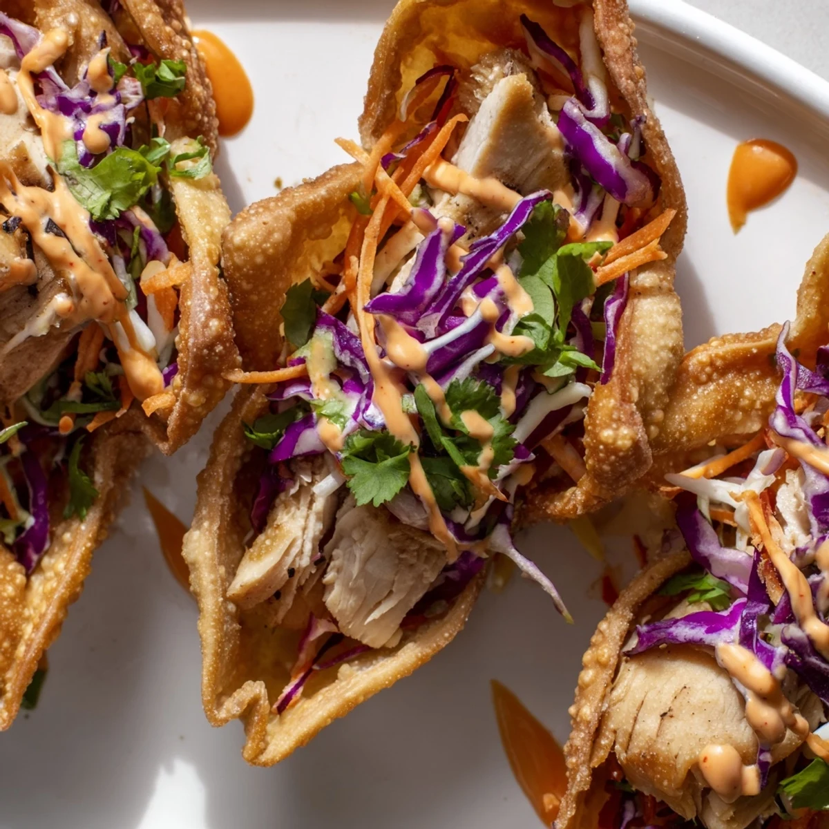 Crispy fried wonton tacos stuffed with marinated Asian chicken and crisp vegetable slaw garnished with cilantro