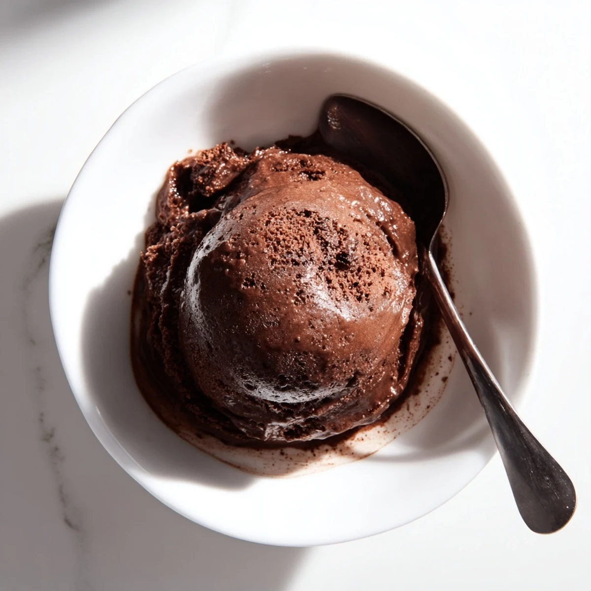 Creamy chocolate sourdough ice cream scooped into a bowl with dark chocolate shavings on top