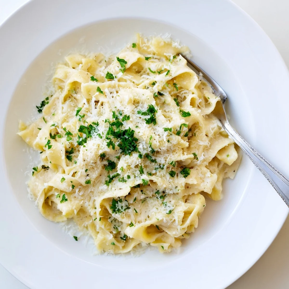 Tender egg noodles tossed in a savory white cream sauce with onions and Parmesan