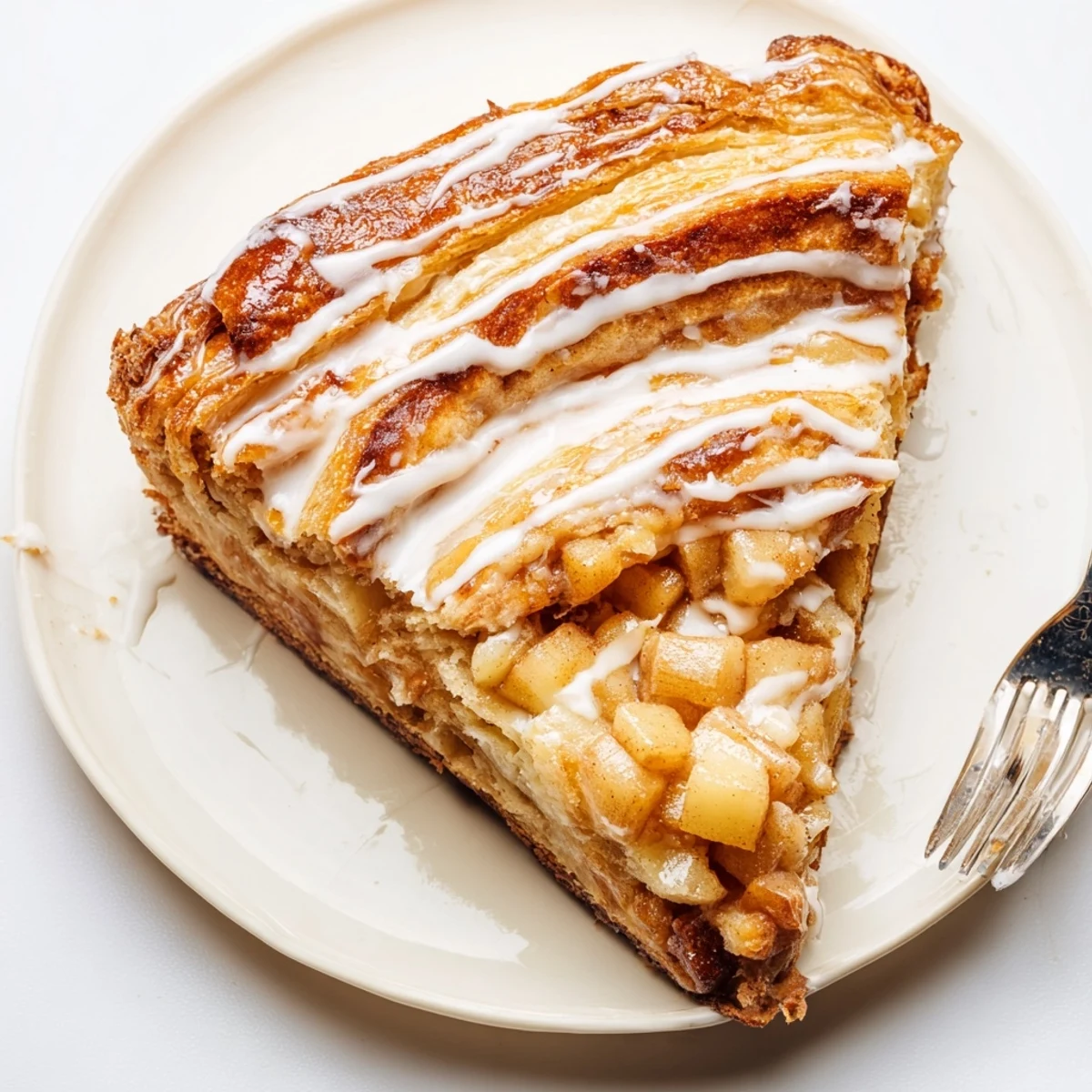 Buttery pastry filled with creamy cheese and tender cinnamon apples on a white plate